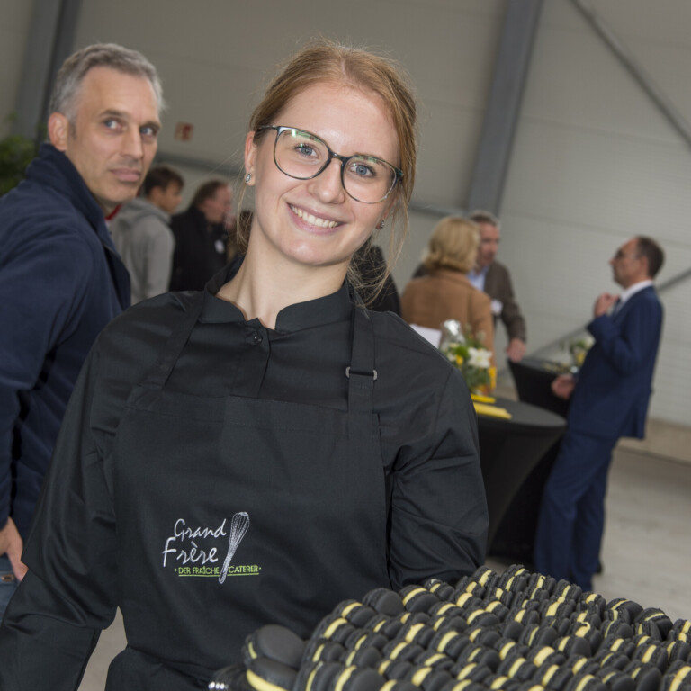 1. Elegante Catering-Mitarbeiterin mit Macarons bei Grand Frère Catering.