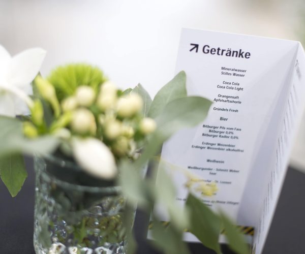 Frühstücksbereich mit Getränkekarte und Blumen, Catering-Service Grand Frère.