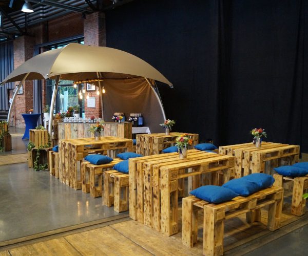 Rustikale Palettenmöbel mit blauen Kissen für Catering-Events bei Grand Frère.
